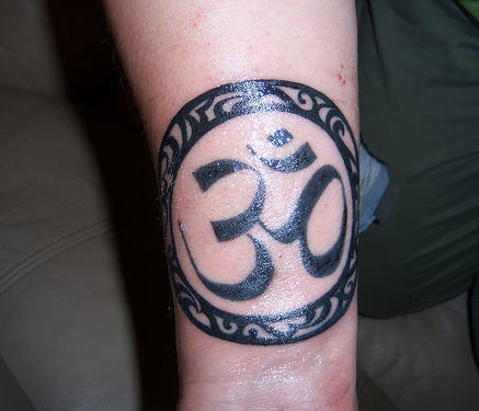 Shining Black Om Tattoo On Wrist