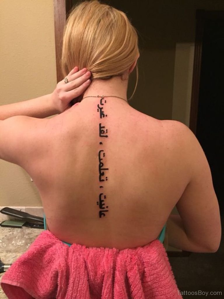 back of a woman with a tattoo of a detailed symmetrical arabic poem