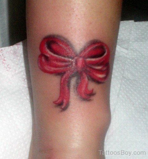 Red Ink Bow Tattoo On Leg-